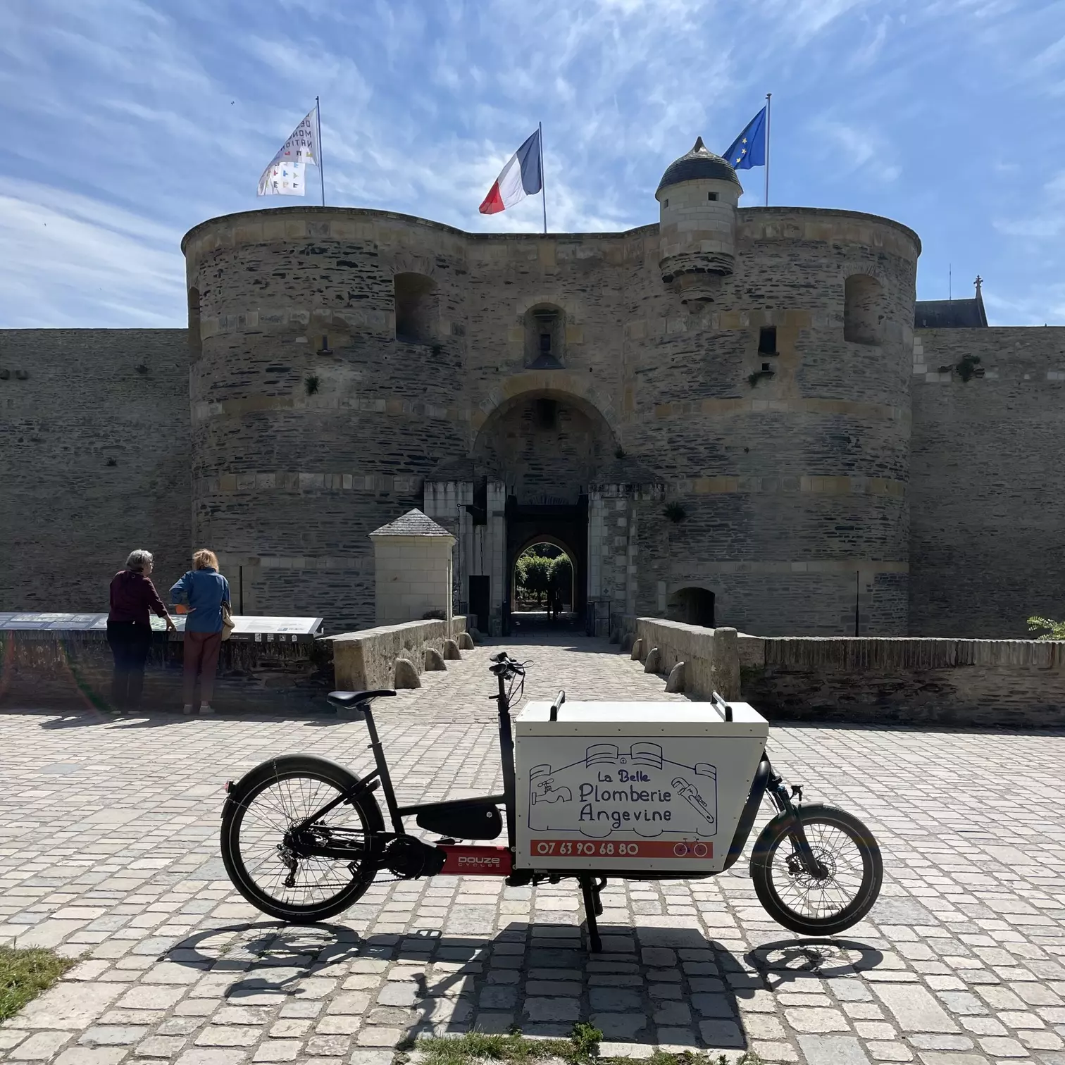 Le vélo cargo de La Belle Plomberie Angevine devant le château d’Angers, dans la Doutre